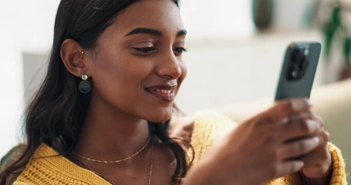 Happy, woman and phone text with social media, home and dating app with smile and flirty message. Couch, mobile networking and website with scroll, swipe and internet search online in living room