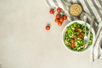 Flatlay with salad, tomatoes, cheese and sesame crackers.