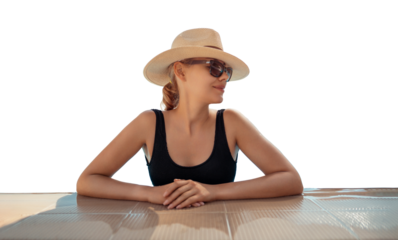 Girl in hat is in pool, leaning on side. Young woman with glasses and hat on vacation is relaxing on edge of pool on sunny day. Portrait of woman in pool looking at camera. Sitting on edge of pool