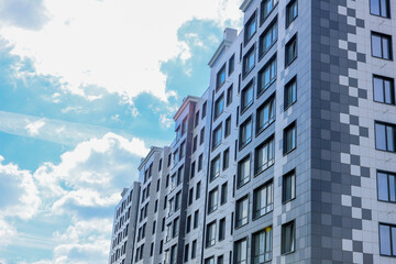 Fototapeta premium A contemporary apartment building showcasing unique artistic design elements set against a clear blue sky