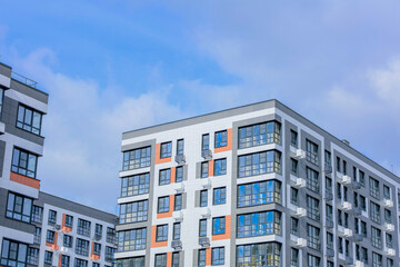 This is a modern apartment complex featuring expansive windows and lively accents situated in a...