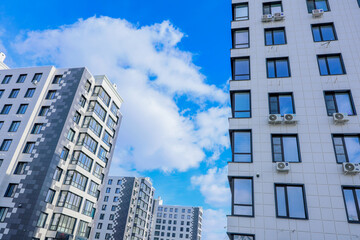 Naklejka premium Contemporary buildings featuring air conditioning units, set against clear skies, showcasing urban living and lifestyle