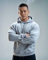 Man in grey hoodie with arms crossed