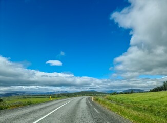 Asphalt road crossing Iceland under a cloudy sky