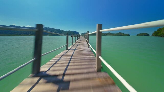 aerial drone fly pass through wooden bridge and ascending to reveal blue sea, Nakhon Si Thammarat, Thailand 
