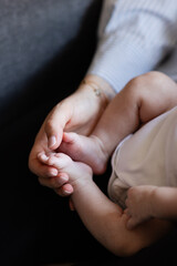 closeup of woman's hands holding newborn's feet