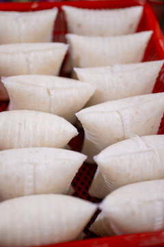 Several compressed rice cakes, likely Nasi Impit or Ketupat, are shown in a close-up view. 