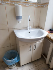 A white sink sitting under a mirror in a bathroom