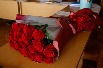 A bouquet of red roses sitting on top of a wooden table