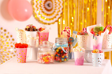 Candy bar. Many different sweets on table in festive decorated room