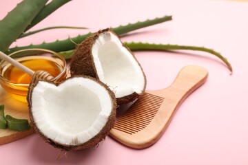 Hair treatment. Fresh coconut, honey, comb and aloe leaves on pink background, closeup