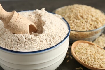 Brown rice and flour on grey table, closeup