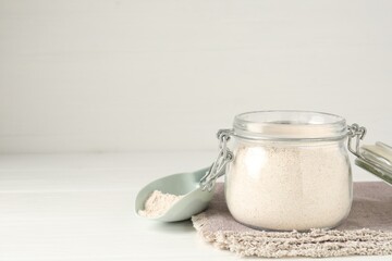 Brown rice flour on white wooden table. Space for text