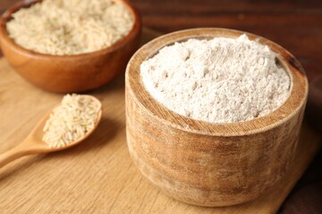 Brown rice and flour on wooden table, closeup