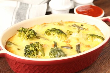 Delicious vegetable casserole and sauce on wooden table, closeup