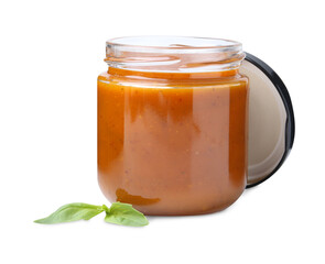 Tasty curry sauce in glass jar and basil isolated on white