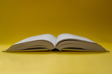 An open book on a yellow background