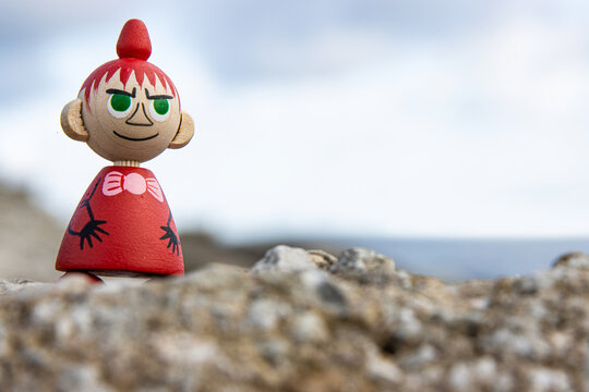 Tallinn, Estonia. September 1st, 2024. Wooden figure of Little My placed on a rock by the sea, symbolizing nordic literature, whimsical characters, and the timeless charm of Tove Jansson moomin creati