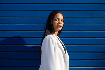 Confident Businesswoman Posing Against Blue Urban Backdrop
