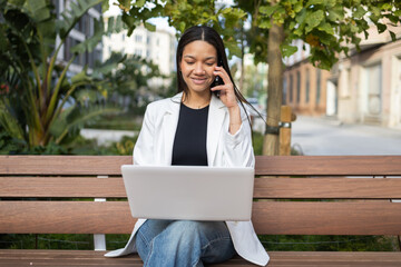 Confident businesswoman multitasking outdoors on a bench