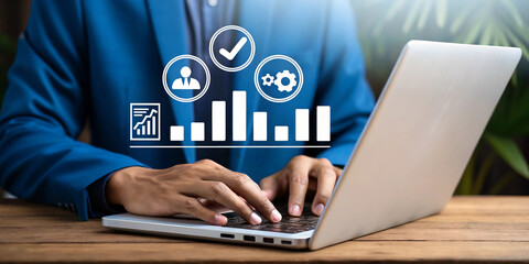 Professional businessperson working on a sleek laptop with digital icons. Modern workspace concept with business analytics and productivity tools. Close-up of hands typing on laptop with overlay of bu