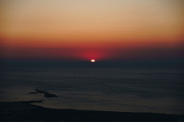 The sun during golden sunset just above the surface of the sea