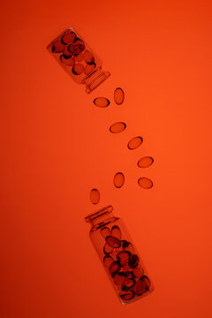 Colorful omega-3 and Vitamin D capsules spilled from glass jars