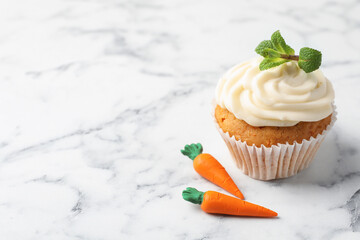 Delicious carrot cupcake with mint on white marble table, closeup. Space for text