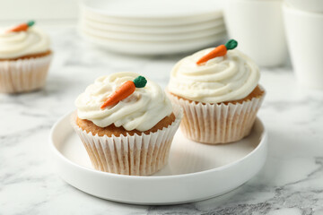 Delicious carrot cupcakes on white marble table, closeup
