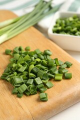 Cut fresh green onions on table, closeup