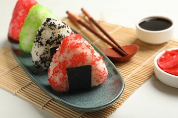 Tasty tobiko onigiri (Japanese rice balls) served on white table, closeup