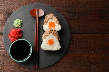 Tasty onigiri (Japanese rice balls) with tuna served on wooden table, top view. Space for text