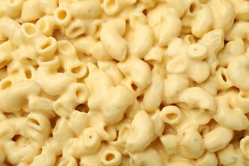 Delicious pasta with cheese sauce as background, top view