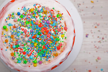Delicious cake and sprinkles on light table, top view