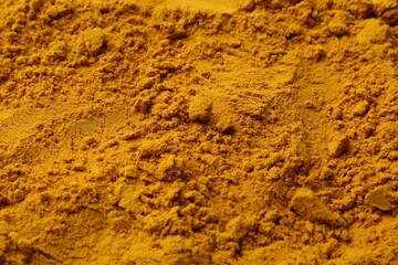 Superfood supplement. Turmeric powder as background, closeup