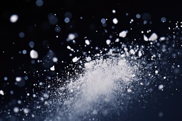 Obraz premium Abstract image of white particles exploding against a dark background, creating a dynamic and energetic visual.