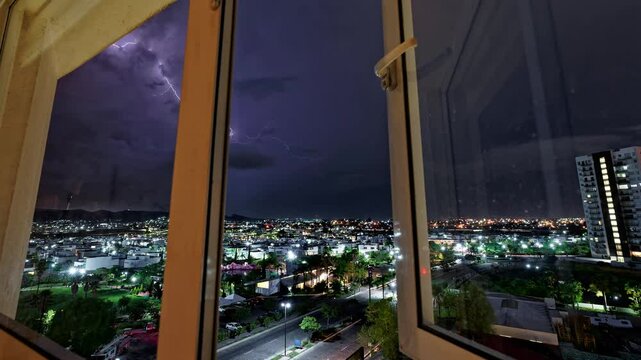 Horizontal landscaped video of Puebla cityscape with purple lightnings during nighttime