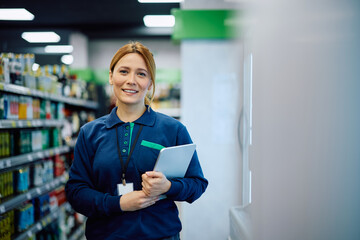 Happy store manager with touchpad looking at camera.