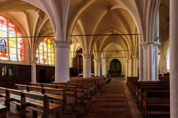 The church is very long and has many pews. The pews are empty