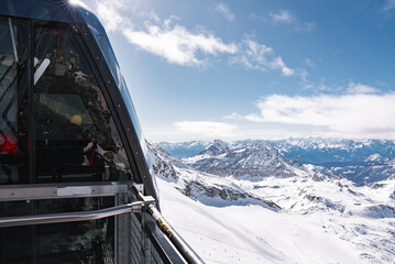Snowy alpine landscape near Zermatt, Switzerland, featuring a modern glass ski lift station,...