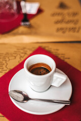 Espresso served on a red napkin in a cozy cafe setting