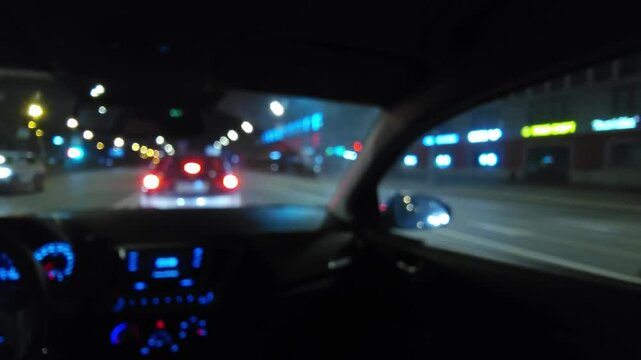Night city view from inside a moving car with blurred lights and motion, concept of urban travel, speed, technology and modern lifestyle