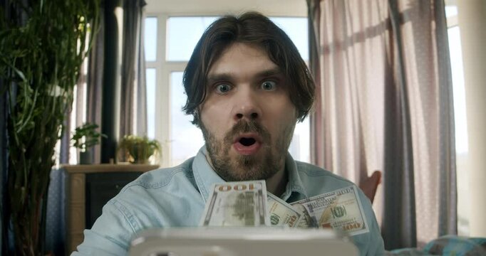 Man make money online, tapping smartphone screen. Money rain flow through the smartphone. Cash flow, dollar bills floating in the man face. Online winning. Business making easy money online concept