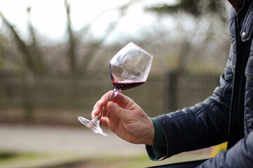 Enjoying a glass of red wine outdoors on a chilly afternoon	