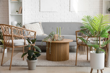 Coffee table with aroma candles and houseplants in bright living room