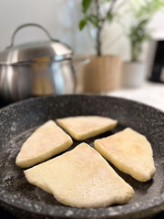 Freshly Cooked Dough Being Prepared on a Pan in a Contemporary Kitchen Environment