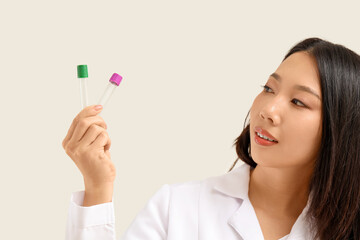 Asian woman holding empty test tubes on white background