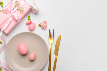 Beautiful Easter table setting served with pink gifts, flowers and eggs on white background