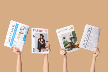 Female hands with magazines and newspapers on color background