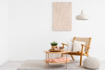 Stylish interior of white living room with cozy armchair, coffee table and picture